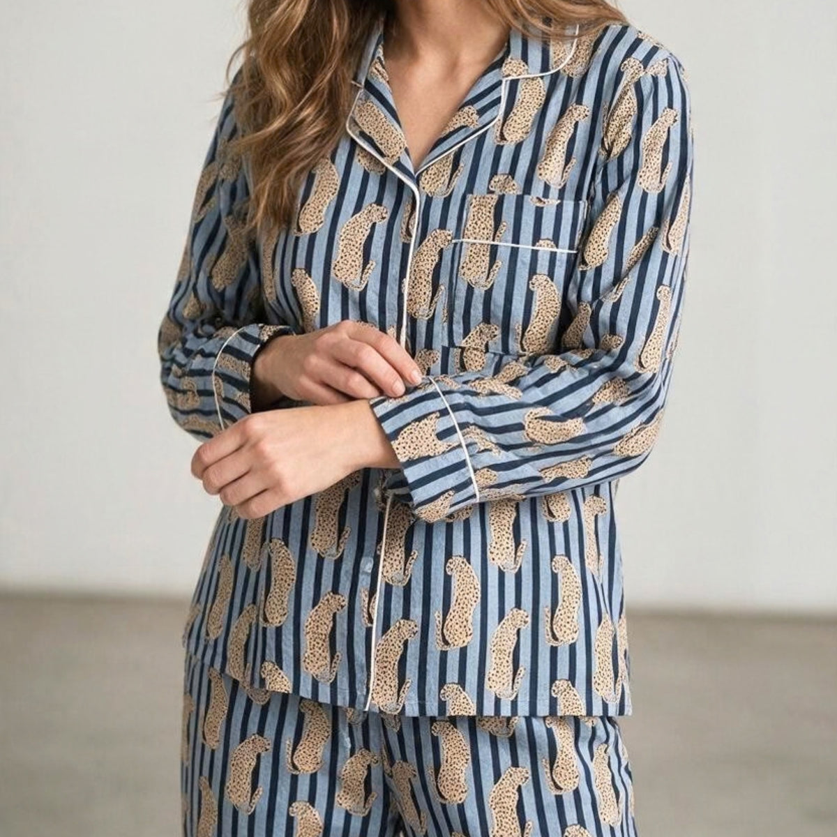 Light blue and dark striped cotton pyjama set featuring a leopard print and white piping, shown with a matching fabric travel pouch.