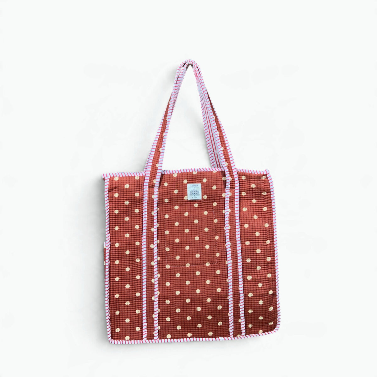 Terracotta quilted cotton tote bag with cream polka dots and pink and white striped piping and handles