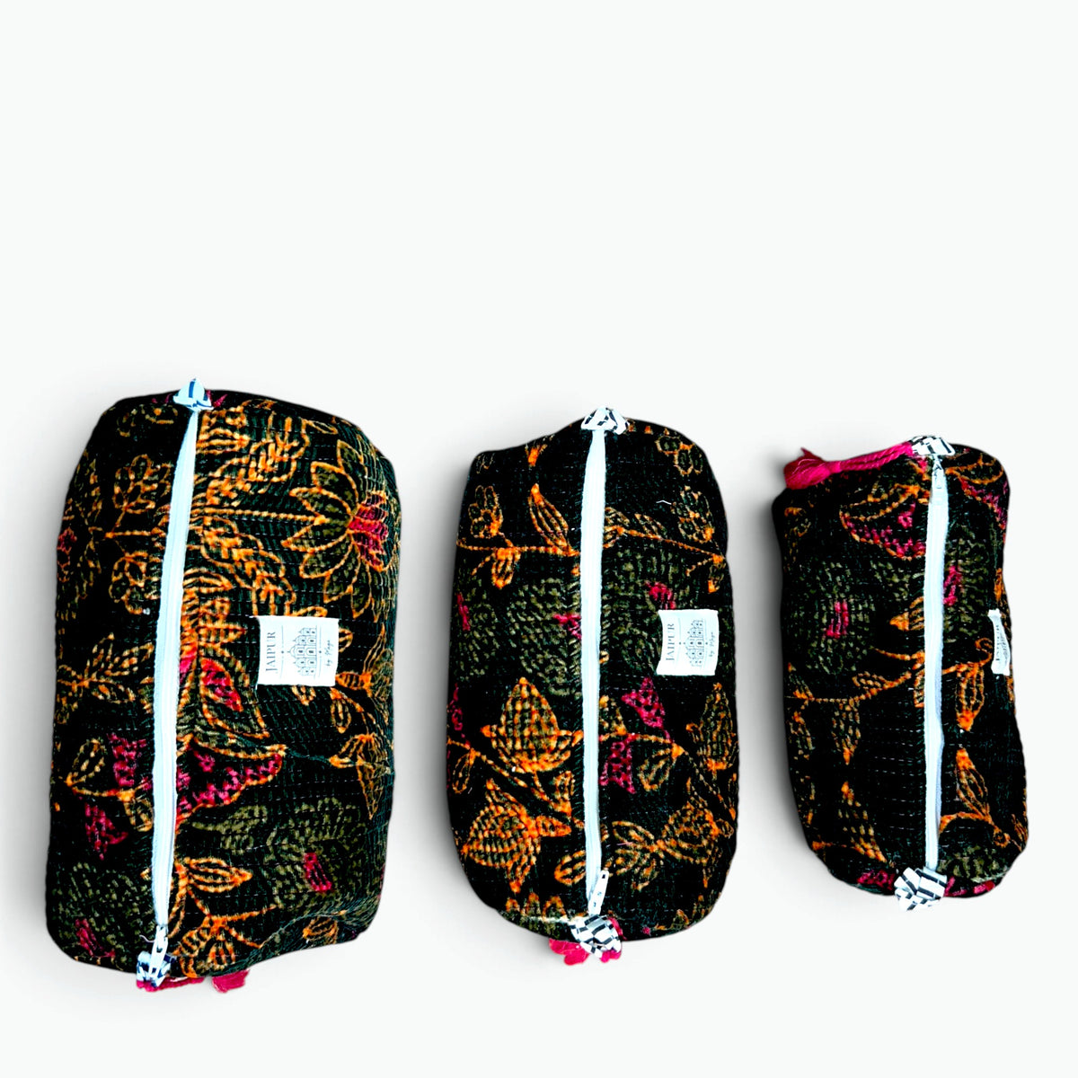 Three black zippered travel pouches with colorful floral and leaf patterns in orange, pink, and green, arranged in descending size order on a white background.