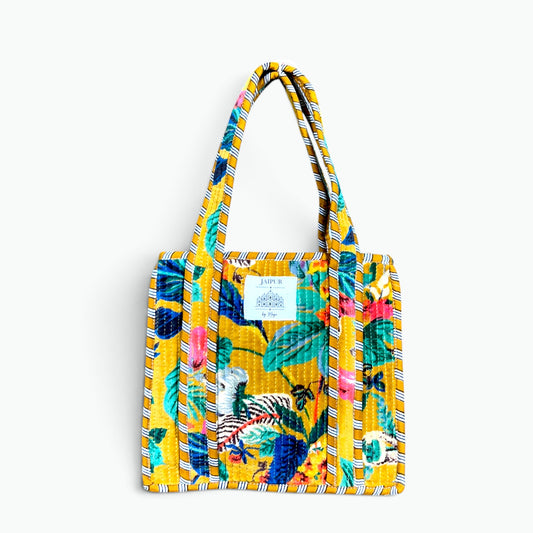 Small mustard yellow quilted velvet tote bag with tropical floral print and mustard and navy striped piping and handles