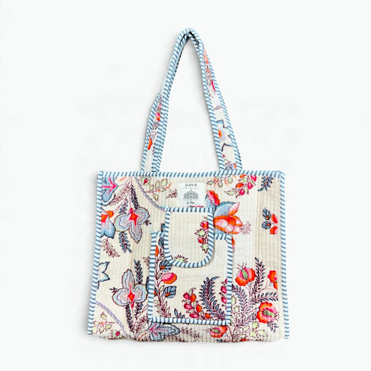 Cream quilted velvet tote bag with coral, pale blue and pink floral print, front pocket and blue-grey striped piping and handles