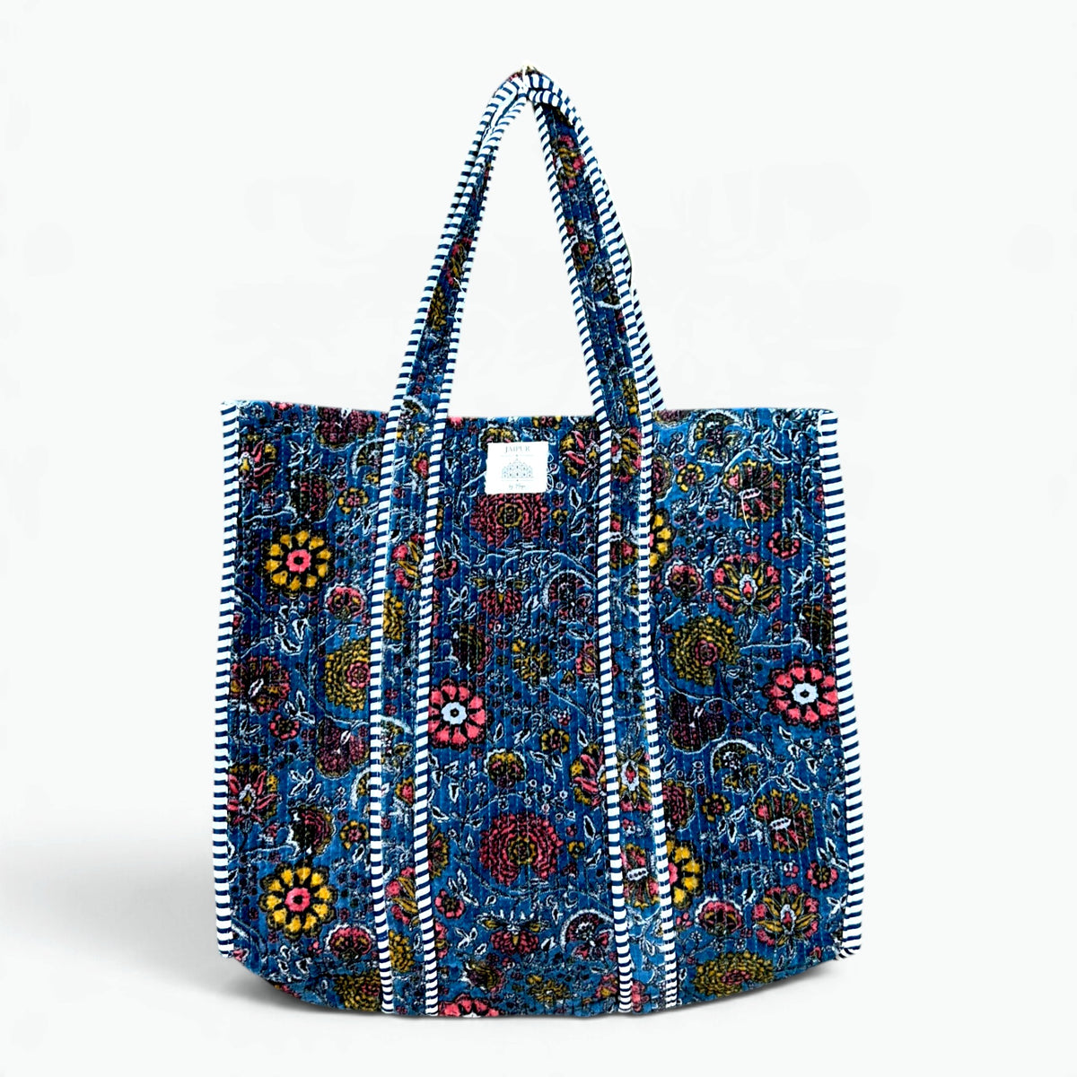 Large blue quilted velvet tote bag with coral pink, mustard and plum floral print and navy and white striped piping and handles