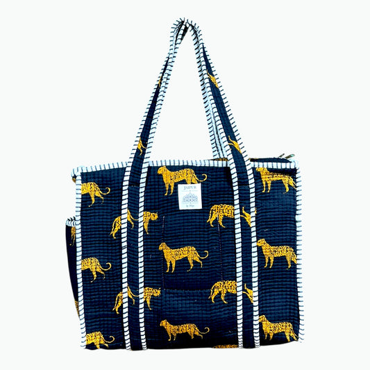 Black quilted cotton zip tote bag with golden leopard print and black and white striped piping and handles