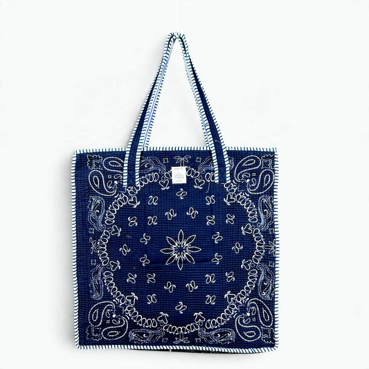 Navy blue quilted cotton tote bag with white bandana paisley print and navy and white striped piping and handles