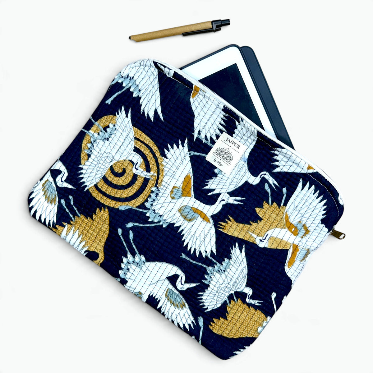 Navy quilted cotton iPad sleeve with white crane and gold sun print, with a tablet and pen