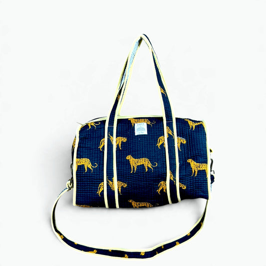 Navy quilted cotton mini duffle bag with golden leopard print, butter yellow piping, carry handles and shoulder strap