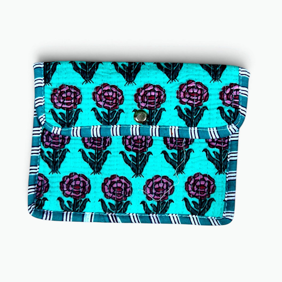 A fabric tablet sleeve or wallet featuring a turquoise background with a purple and black floral pattern, finished with a striped blue and white border and a snap button closure.