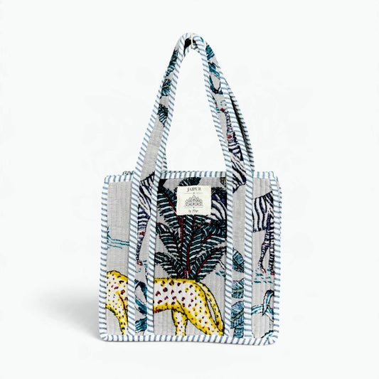 Grey quilted velvet tote bag with zebra, yellow leopard and palm safari print and blue-grey and white striped piping and handles