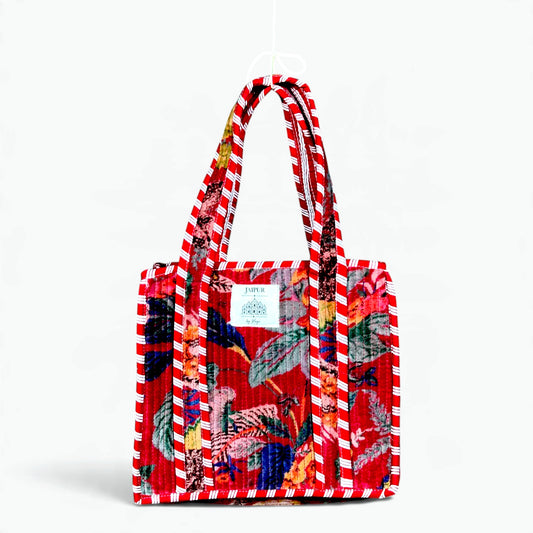 Red quilted velvet tote bag with tropical floral print and red and white striped piping and handles