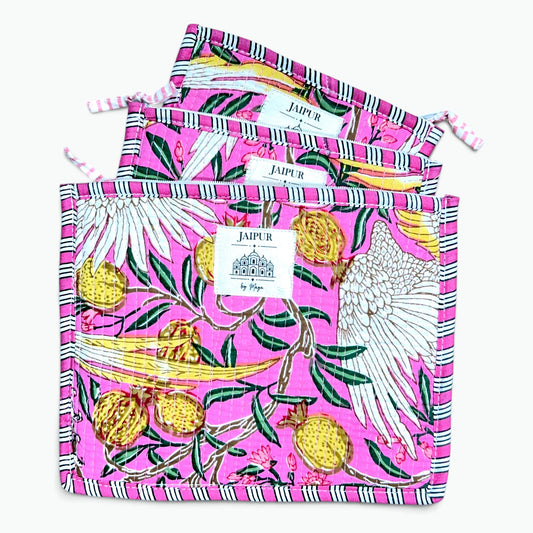 Three pink drawstring pouches with a colorful pomegranate and bird print, arranged in a fan shape on a light gray background.